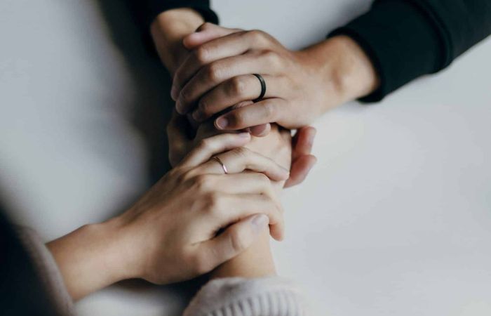 Unas manos que agarran otras manos sobre un fondo blanco