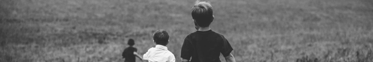 Imagen en blanco y negro de unos niños corriendo sobre un campo